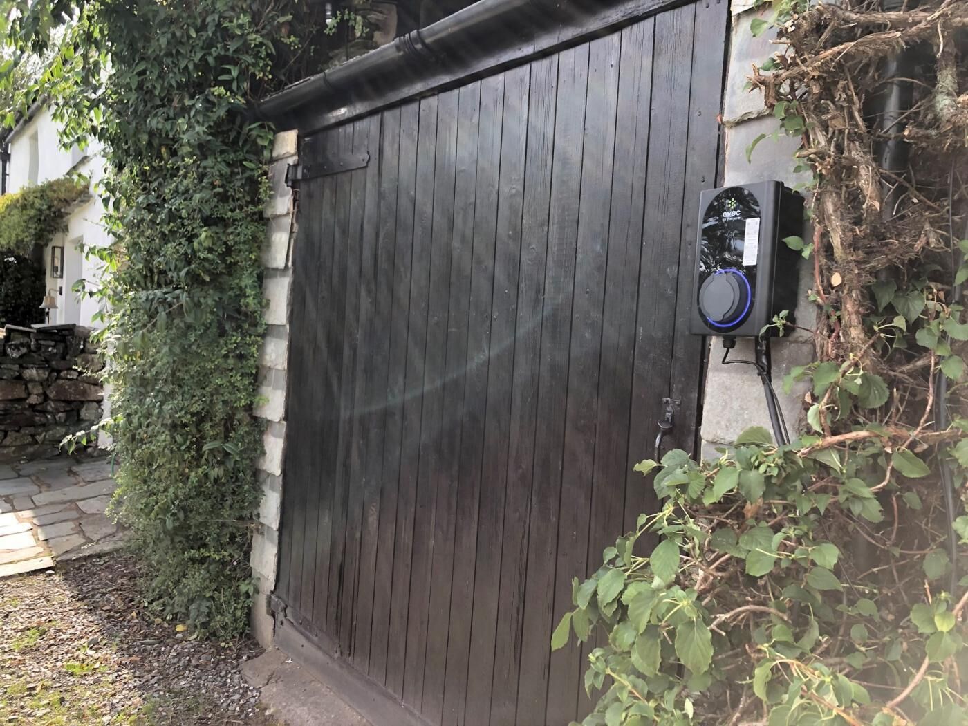 A closed wooden gate with a security device attached to the wall.