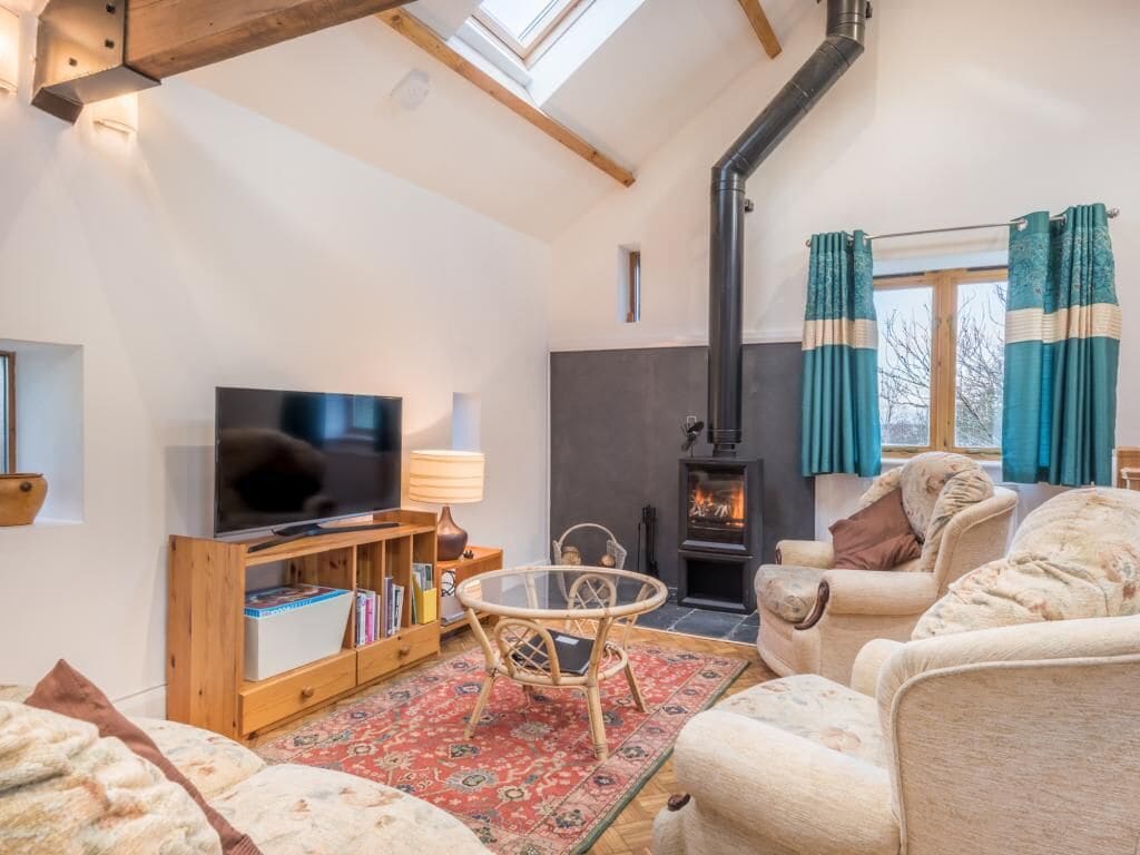 A cozy living room with a television, sofa, and a fireplace.