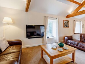 A living room with a TV, two leather sofas, a wooden coffee table, and a window with curtains. - 3 Bed in Eyam (oc-pk835) (Eyam)