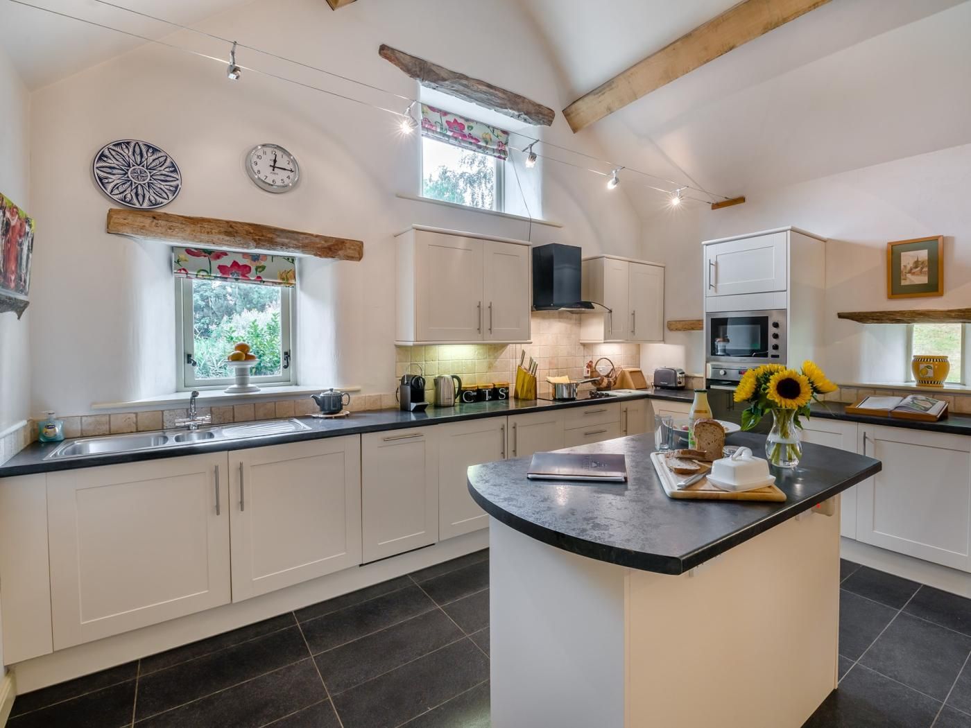 A modern kitchen with a central island, built-in appliances, and a window with a view.