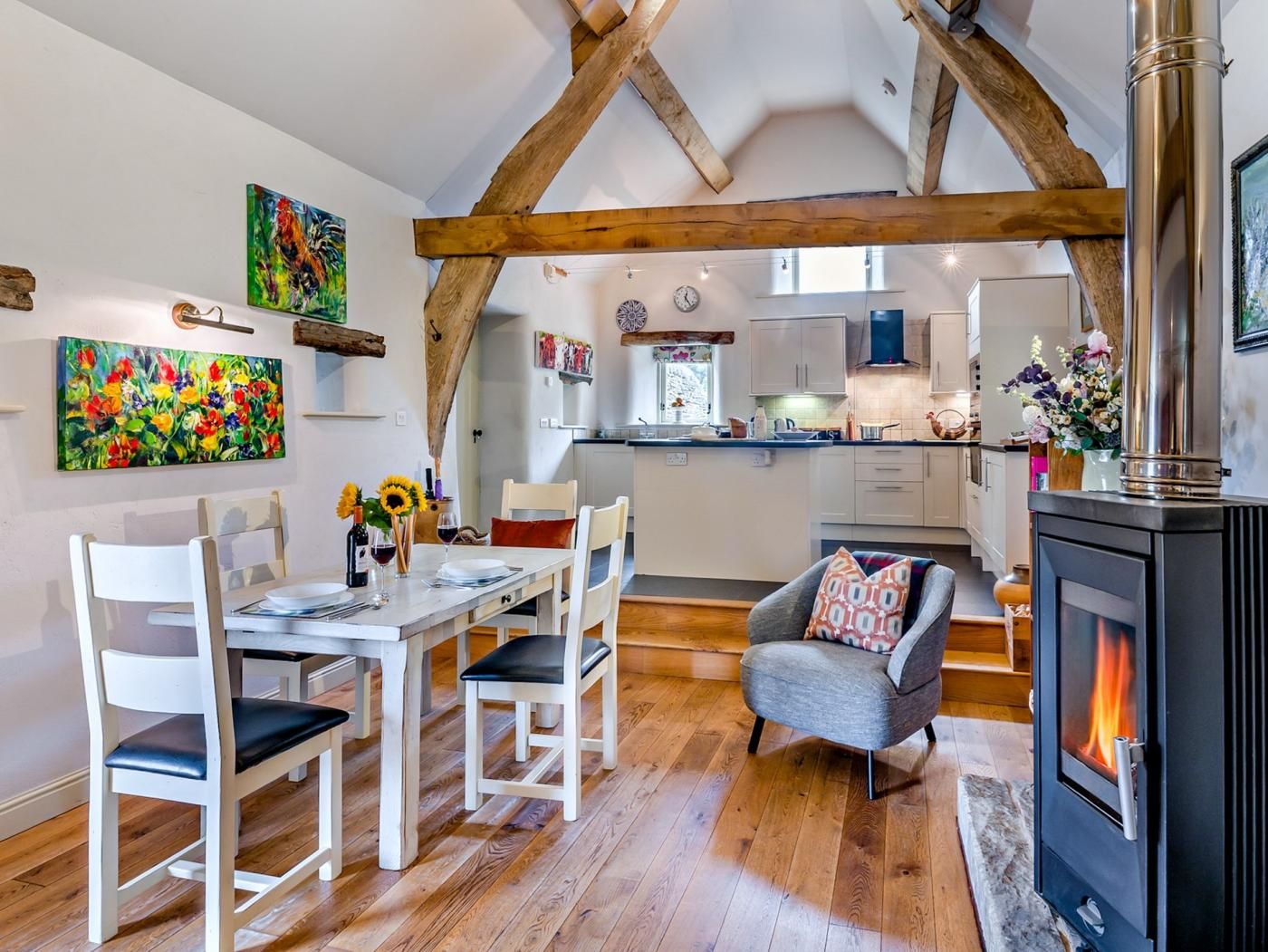 Un interior acogedor con comedor, cocina y chimenea.