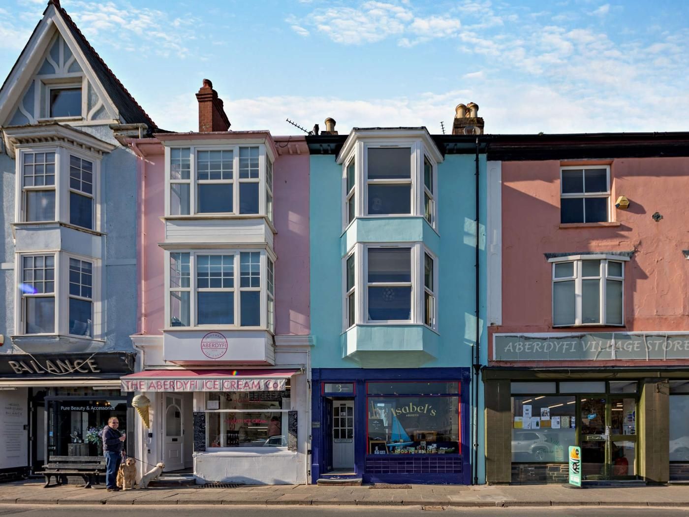 Une rangée de bâtiments aux couleurs vives, avec différentes devantures de magasins, dont une nommée « The Aberdyfi Ice Cream Co. » et une autre nommée « Isabel's ».