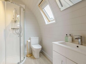 A modern bathroom with a glass-enclosed shower, a white toilet, and a vanity with a sink and two bottles of liquid soap. - 2 Bed in Tain (oc-81340) (Nigg)