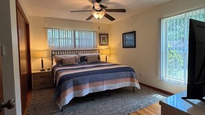A bedroom with a bed, a ceiling fan, a window with blinds, a bedside lamp, and a TV. - Touchdown on Terrace - Gator Retreat 1 mile to UF - Sleeps 6. (Gainesville)
