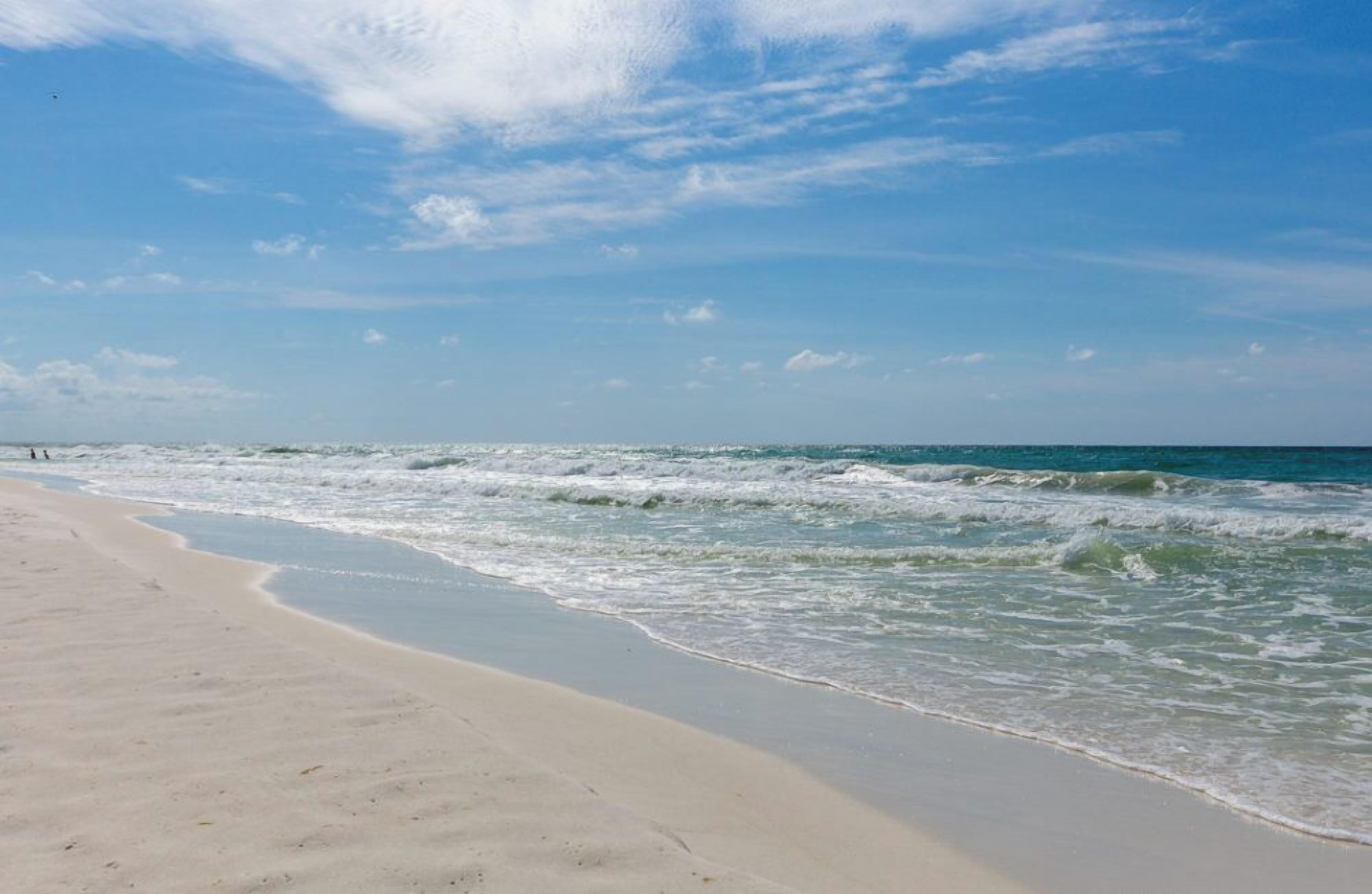 Una playa con arena y olas.