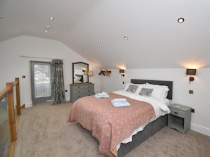 A bedroom with a bed, bedside tables, a dresser, a mirror, and a window with curtains. - 2 Bed in Carnforth (oc-sz605) (Hutton Roof)