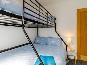 A bunk bed with a headboard, a bedside table with a lamp, and a wooden door. - 2 Bed in Brixham (oc-88998) (Brixham)
