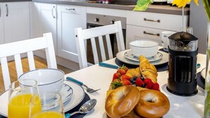 Colazione con cornetti, fragole, mirtilli e succo d'arancia su un tavolo.