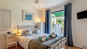 Ein Schlafzimmer mit einem Bett, einem Nachttisch, einer Lampe und einem Deckenventilator.