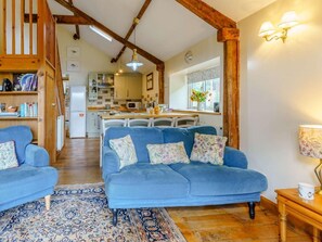 A cozy living room with a blue sofa, a patterned rug, and wooden beams. - 3 Bed in Brecon (oc-bn065) (Crai)