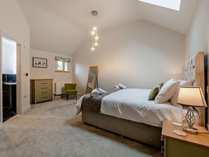 A bedroom with a bed, bedside table, lamp, dresser, chair, and a mirror. - 3 Bed in Harrogate (oc-94743) (Pateley Bridge)