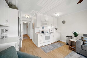 Eine moderne Küche mit weißen Schränken, einer Mikrowelle und einer Kaffeemaschine.