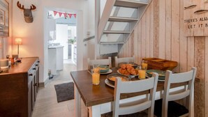 Eine moderne Küche mit einer Holztischinsel, weißen Stühlen und einer Frühstücksecke.