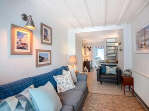 A living room with a sofa, a coffee table, and a lamp. There are framed pictures on the wall. - 2 Bed in Cromer (oc-kt154) (Cromer)
