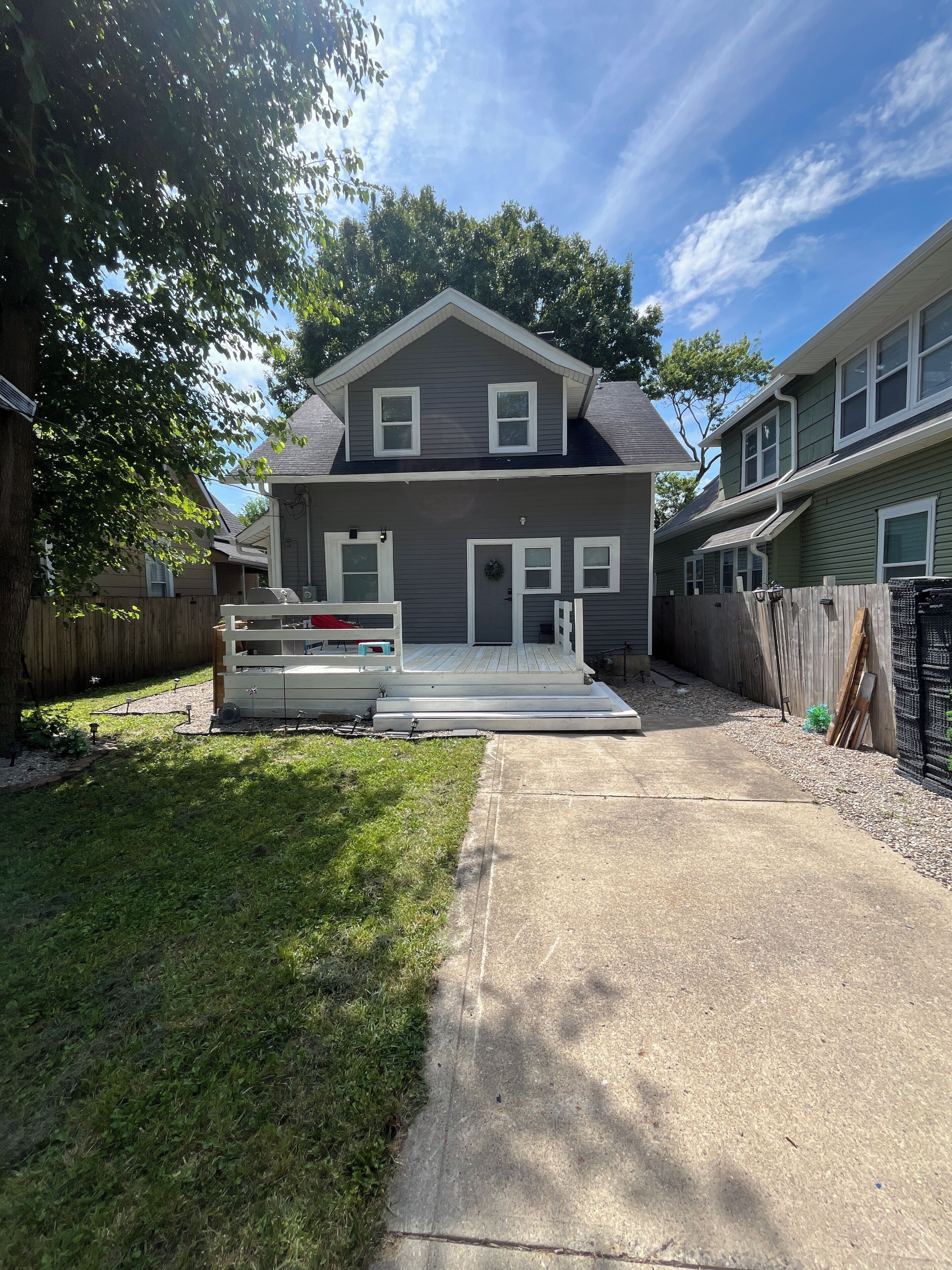 A two-story house with a front porch, a garage, and a fenced backyard.