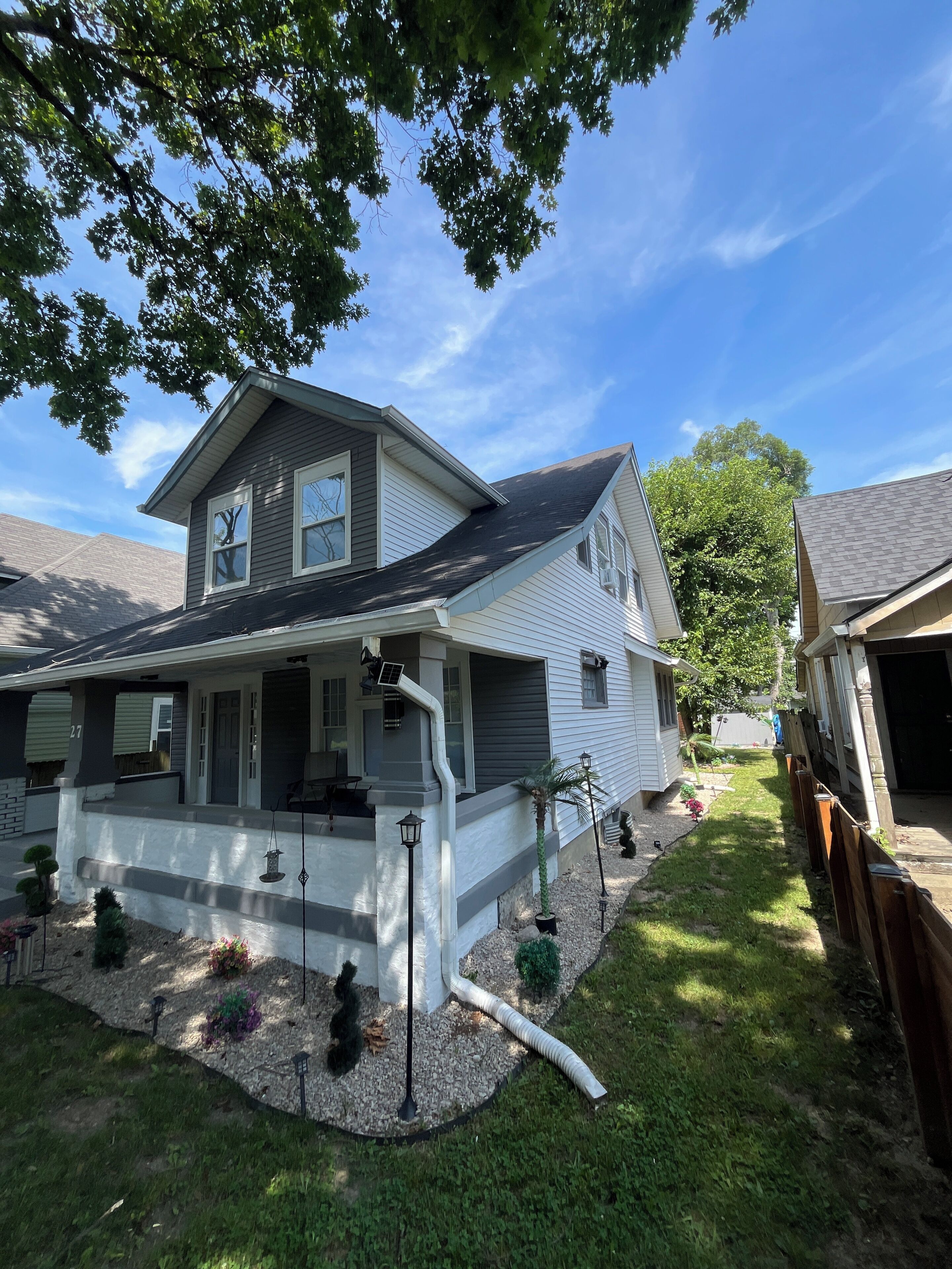 A two-story house with a front porch, a garage, and a well-maintained lawn.