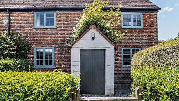 A brick house with a white door, two windows with shutters, and a small garden. - 1 Bed in Wootton (oc-ic159) (Wootton Bridge)