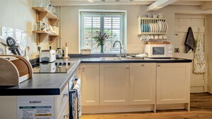 A kitchen with white cabinets, a microwave, a sink, and a window with blinds. - 1 Bed in Wootton (oc-ic159) (Wootton Bridge)
