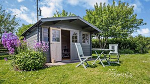 A small wooden cabin with an open door, a table, and two chairs outside. - 1 Bed in Wootton (oc-ic159) (Wootton Bridge)
