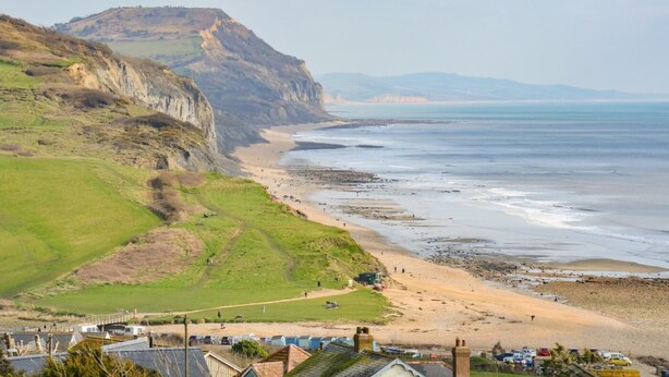 A coastal landscape with a beach, cliffs, and a view of the sea. - 3 Bed in Bridport (oc-94692) (Fernhill)