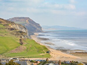 A coastal landscape with a beach, cliffs, and a view of the sea. - 3 Bed in Bridport (oc-94692) (Fernhill)