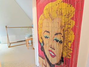 A room with a whiteboard, a small wooden table, and a wall with a colorful artwork. - 2 Bed in Brockenhurst (oc-92220) (Furzey Lodge)
