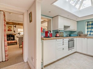 A modern kitchen with white cabinets, a skylight, and a view into the living area. - 2 Bed in Brockenhurst (oc-92220) (Furzey Lodge)