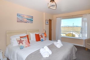 A hotel room with a bed, a window with a view, and a painting on the wall. - 4 Bed in Paignton (oc-56920) (Paignton)