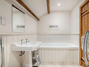 A bathroom with a white sink, a bathtub, wooden beams on the ceiling, and a framed picture on the wall. - 2 Bed in Exeter (oc-92739) (Longdown)