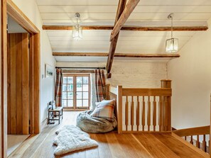 A room with wooden beams, a bed, a bench, a rug, and a window with curtains. - 2 Bed in Exeter (oc-92739) (Longdown)