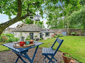 A rustic house with a stone wall, a garden with a lawn, and a table with outdoor seating. - 1 Bed in Richmond (oc-94752) (Forcett)