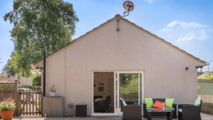 A single-story building with a flat roof, a satellite dish, and a sliding glass door leading to an interior space. - 1 Bed in Fordingbridge (oc-49266) (Frogham)