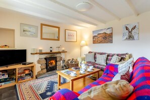 A cozy living room with a fireplace, a television, a sofa, and a coffee table.