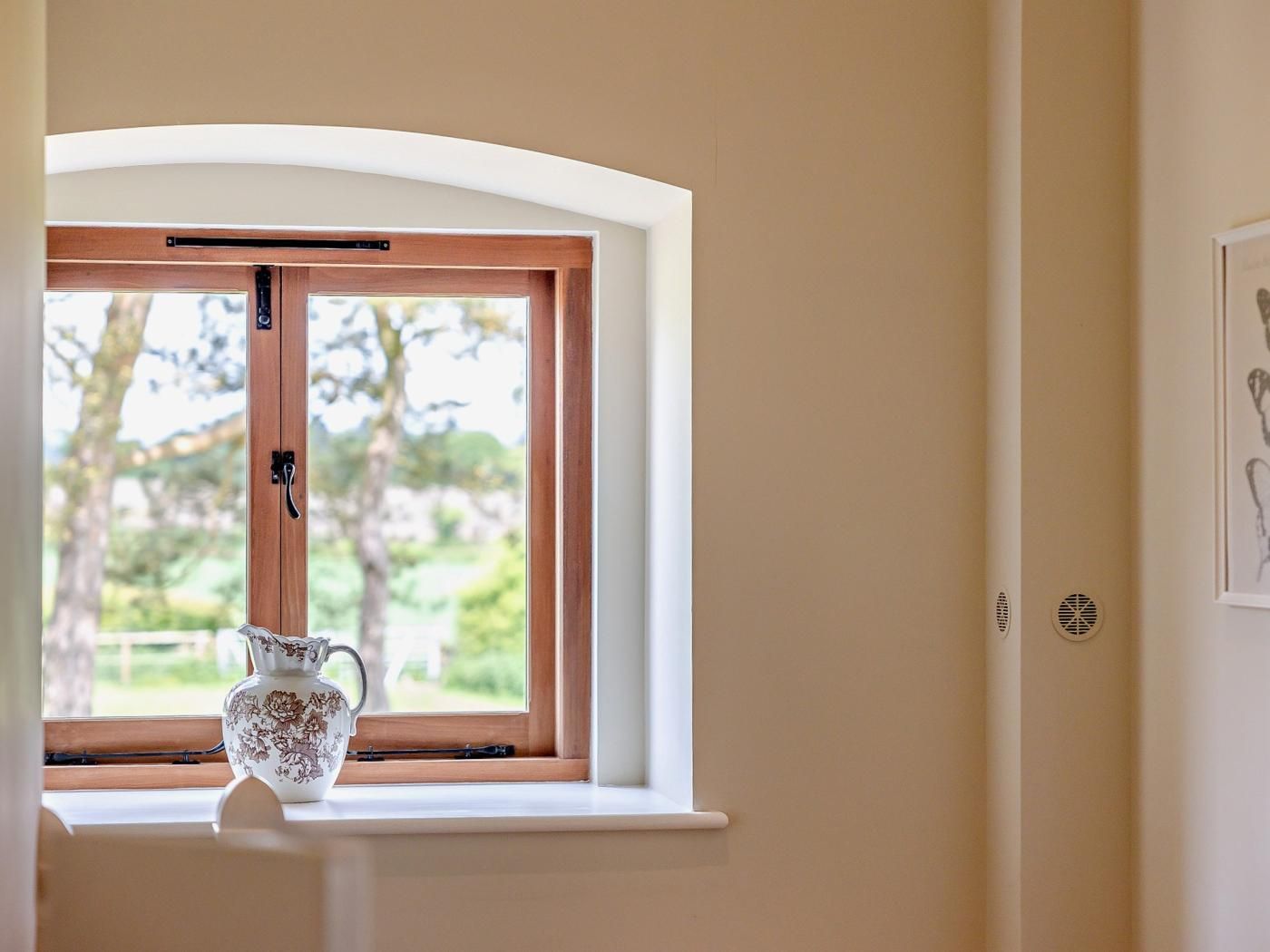 A room with a window, a white wall, and a framed picture.