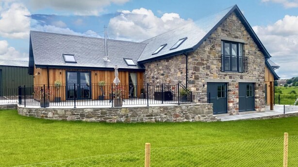 A stone house with a large porch, a fenced yard, and a clear sky. - 2 Bed in Auchterarder (oc-94546) (Auchterarder)