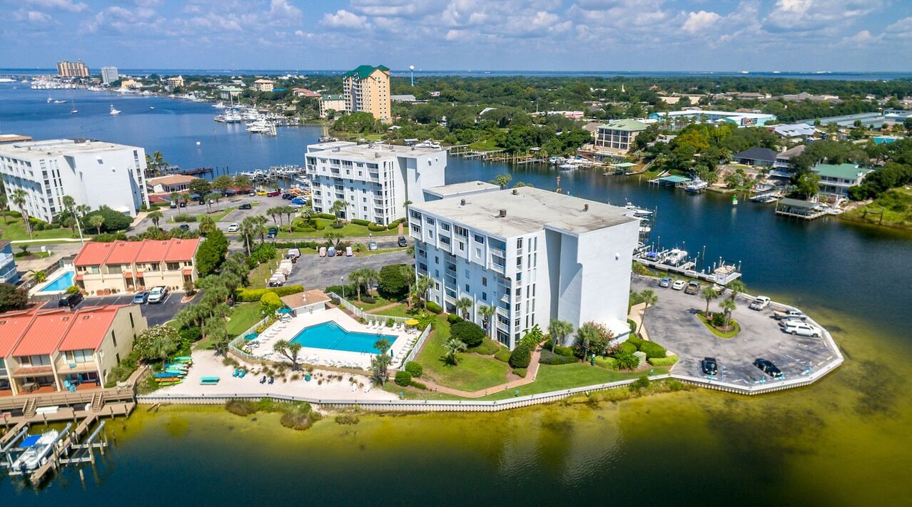 A waterfront hotel with multiple buildings, a marina, and a pool area.