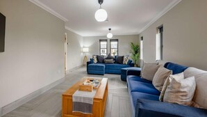 Un salon moderne avec un canapé bleu, une table basse en bois et une lampe.