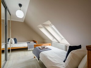 A bedroom with two beds, a skylight, and a modern ceiling light. - 4 Bed in Alexandria (oc-88759) (Balloch)