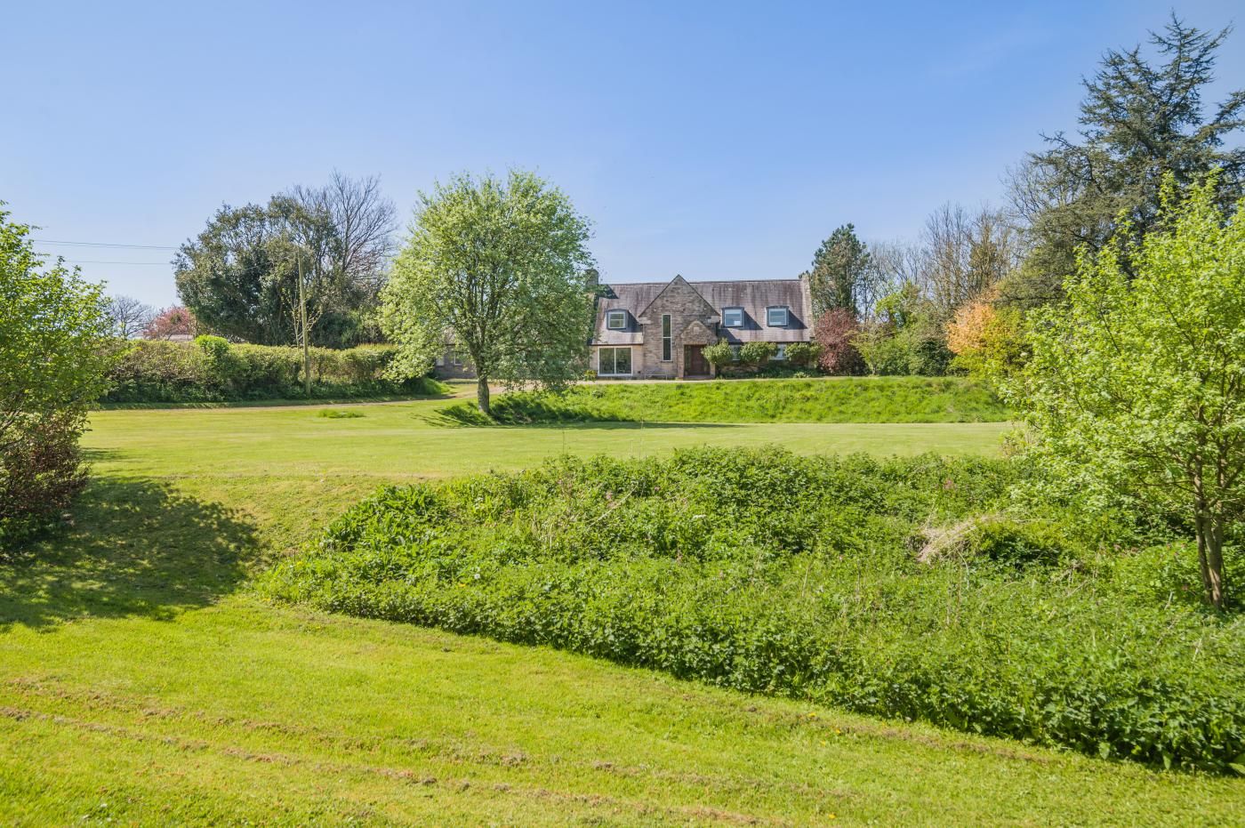 A house with a lawn and hedges.
