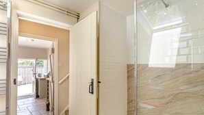A modern bathroom with a glass shower enclosure, a marble backsplash, and a view of the outdoor area. - 2 Bed in Bridport (oc-dc110) (Chideock)