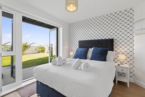 Ein Hotelzimmer mit einem Bett, zwei Nachttischen, einem Fenster mit Blick ins Freie.