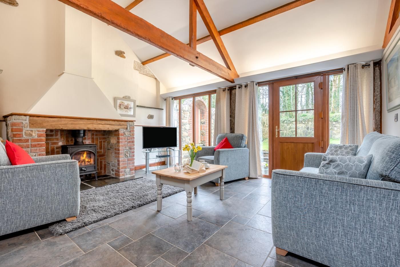 Una sala de estar acogedora con chimenea, asientos cómodos y ventanas amplias.