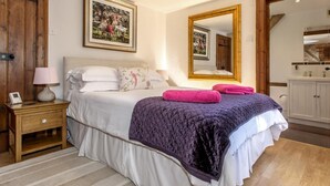 Ein Schlafzimmer mit Bett, Nachttisch, Lampe und einem großen Spiegel.