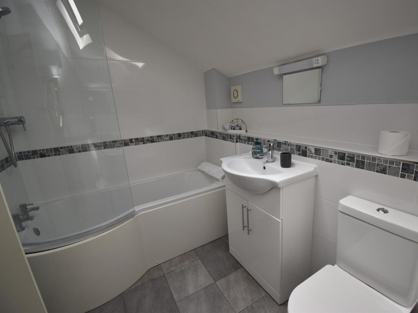 A bathroom with a bathtub, a sink, a toilet, and a shower.
