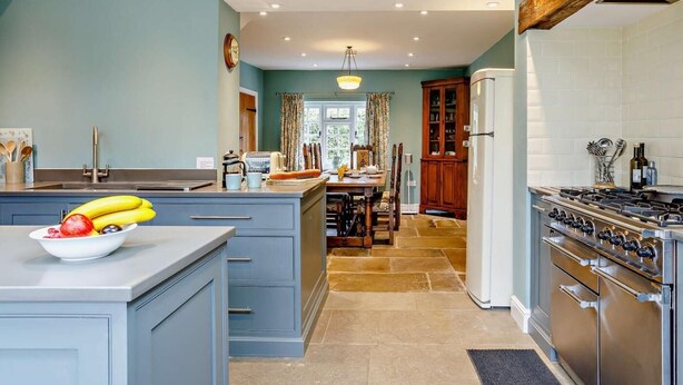A kitchen with a central island, a stove, and a refrigerator. - 4 Bed in Dorchester (oc-dc190) (Winfrith Newburgh)