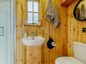 A wooden-paneled bathroom with a white sink, a window above the sink, and towels hanging on a rack. - 1 Bed in Taunton (oc-89989) (Churchstanton)