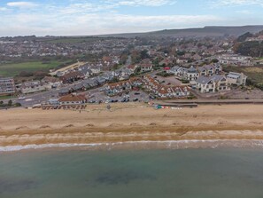 Eine Küstenstadt mit Strand, Wohngebäuden und einer Straße, die zum Strand führt.