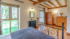 A bedroom with a bed, a radiator, a wooden wardrobe, and a view of the garden. - 2 Bed in Dorchester (oc-dc075) (Frome Whitfield)