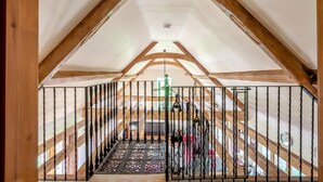 A high-ceilinged attic room with exposed wooden beams, a metal gate, and a patterned floor. - 2 Bed in Dorchester (oc-dc075) (Frome Whitfield)