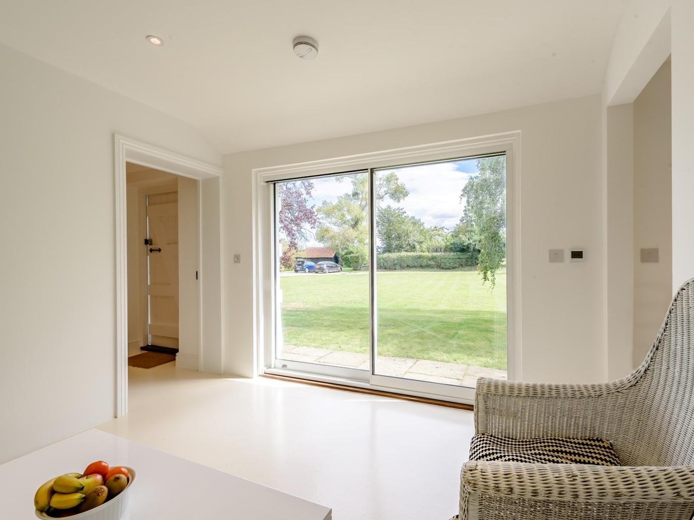 A modern interior with a large sliding glass door leading to a garden.